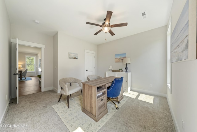 office space featuring light carpet and ceiling fan