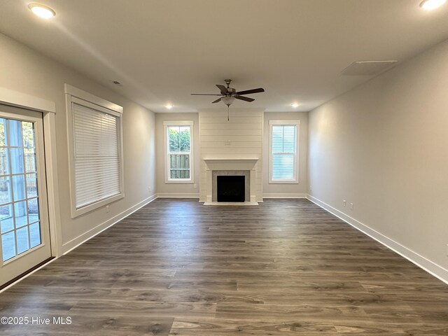 unfurnished living room with dark hardwood / wood-style flooring and ceiling fan