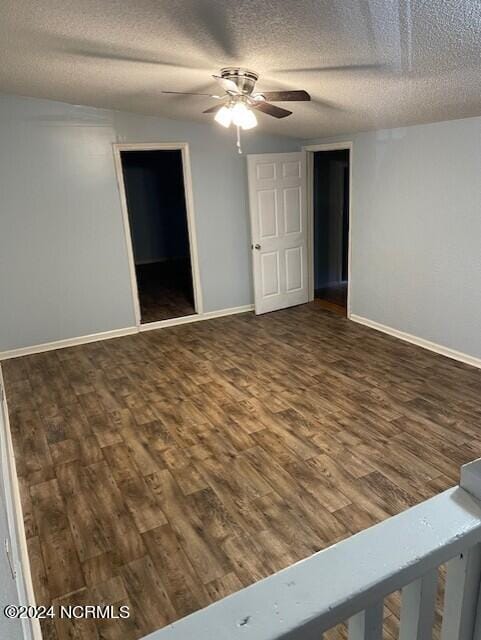 spare room with ceiling fan, a textured ceiling, and dark hardwood / wood-style flooring