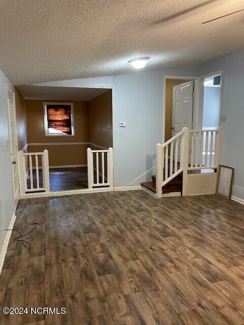 spare room with dark hardwood / wood-style flooring and a textured ceiling