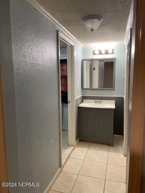 bathroom featuring crown molding, tile patterned floors, a textured ceiling, and vanity