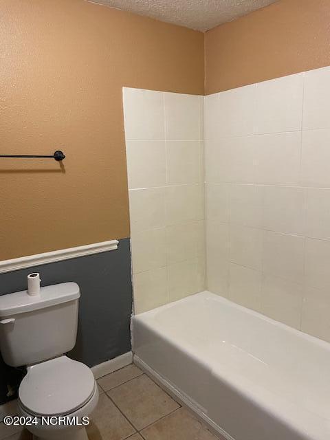 bathroom featuring a textured ceiling, tile patterned floors, independent shower and bath, and toilet