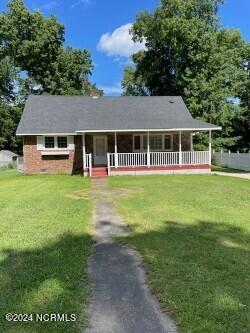 view of front of property featuring covered porch and a front lawn