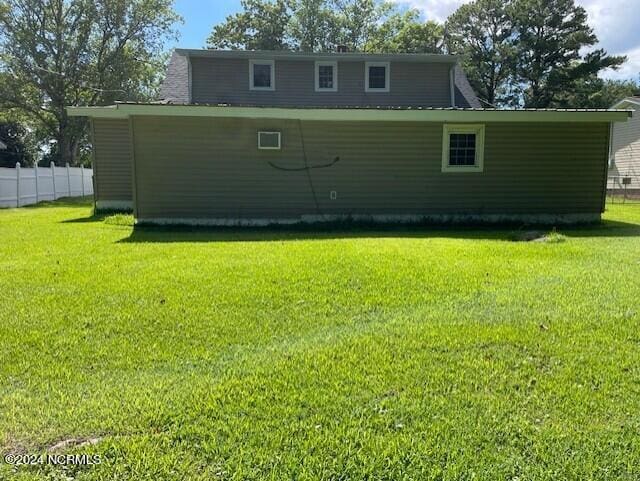 rear view of property with a yard