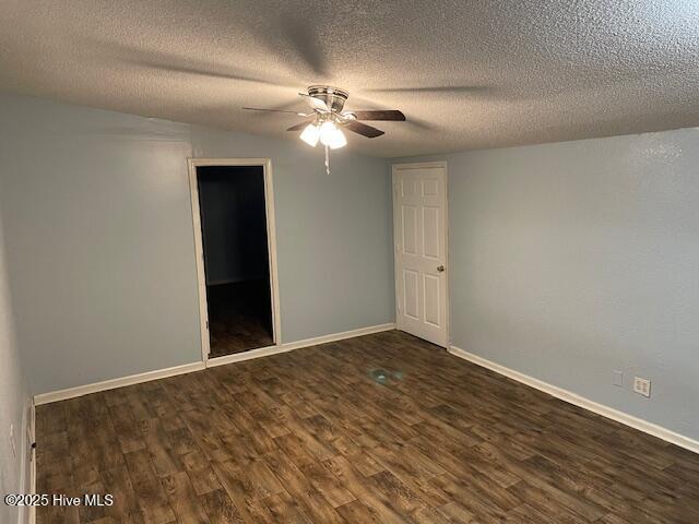 spare room with dark hardwood / wood-style flooring, ceiling fan, and a textured ceiling