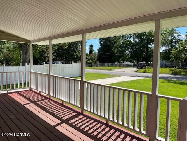 deck featuring covered porch and a lawn