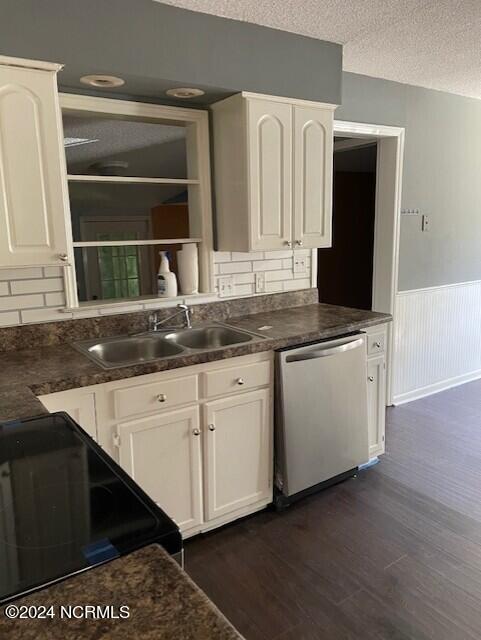 kitchen with stainless steel dishwasher, sink, a textured ceiling, and white cabinets