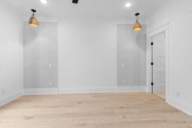 spare room featuring recessed lighting, wood finished floors, baseboards, and ornamental molding