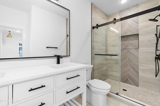 bathroom featuring vanity, a shower stall, and toilet