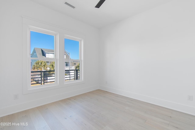 spare room featuring visible vents, baseboards, light wood-style floors, and ceiling fan