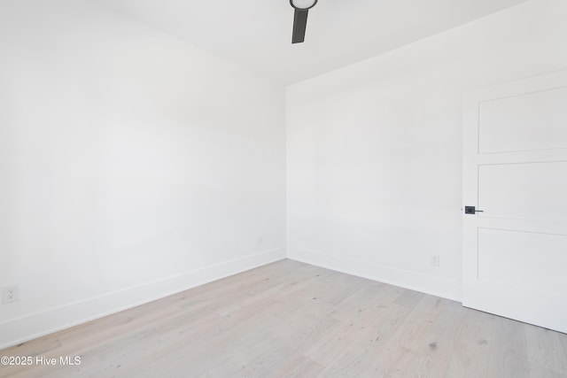 spare room with baseboards, light wood-type flooring, and ceiling fan