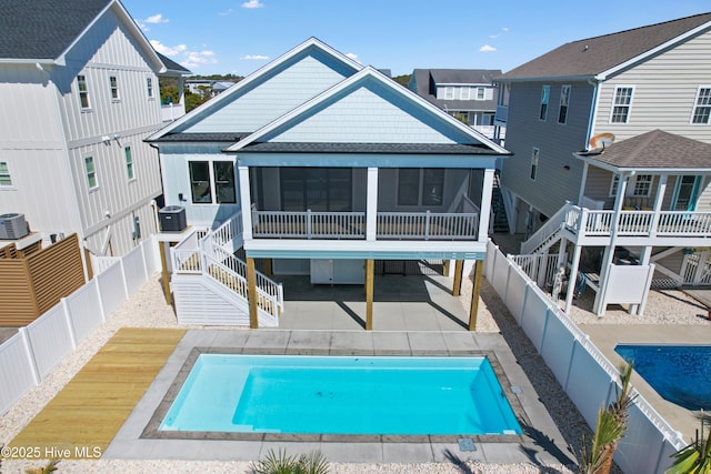 rear view of house with a patio area, a fenced backyard, and a sunroom