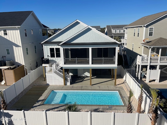 rear view of property featuring stairs, central AC, a fenced backyard, a sunroom, and a patio