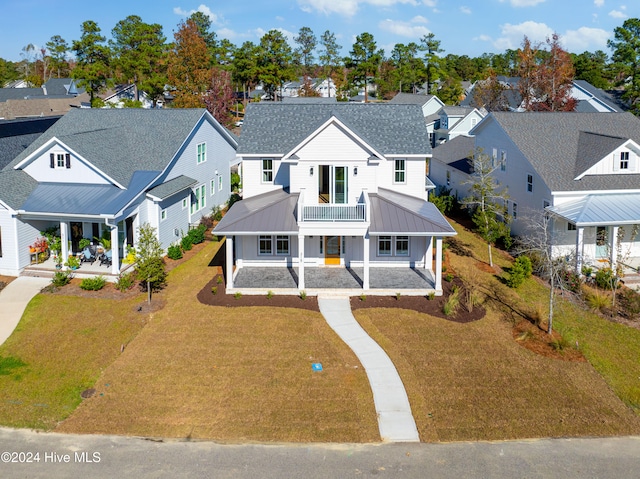 view of front of property with a porch, a balcony, and a front lawn