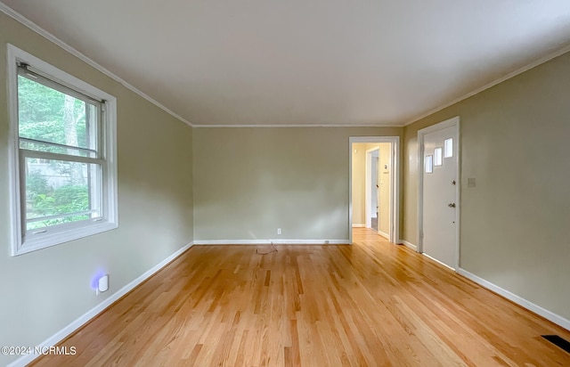 unfurnished room featuring ornamental molding, light wood finished floors, visible vents, and baseboards