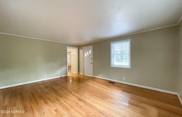 interior space with baseboards, ornamental molding, visible vents, and light wood-style floors