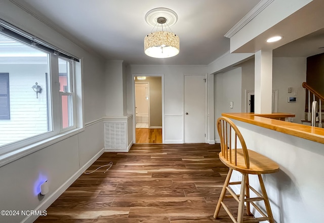 bar with baseboards, wood finished floors, visible vents, and crown molding