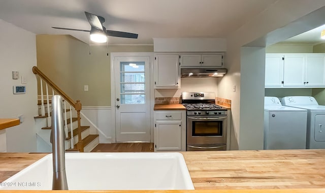 kitchen with a sink, wood counters, separate washer and dryer, under cabinet range hood, and gas range