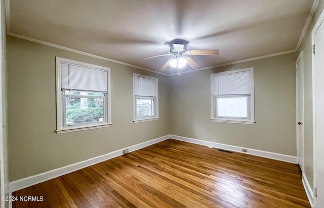 empty room featuring ornamental molding, dark wood-type flooring, and baseboards