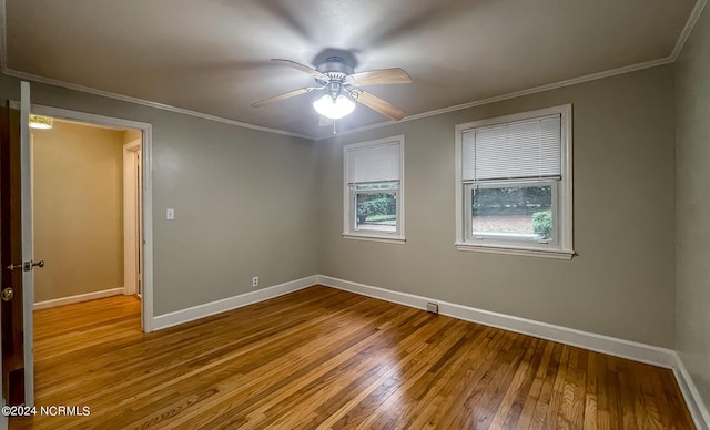 empty room with hardwood / wood-style flooring, ceiling fan, baseboards, and crown molding