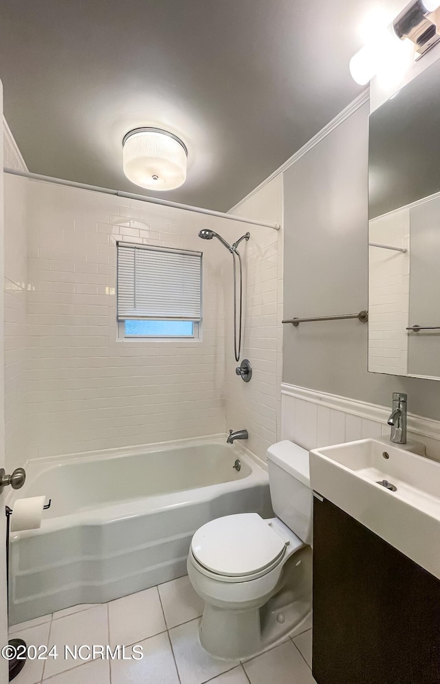 bathroom featuring toilet, a wainscoted wall, tile patterned floors, vanity, and washtub / shower combination