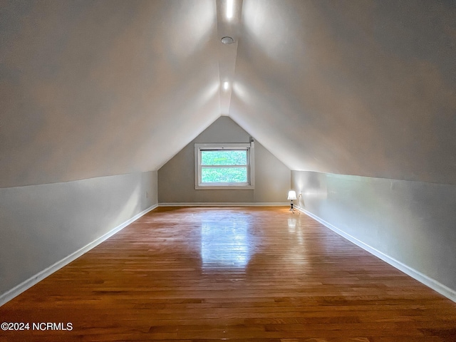 bonus room with baseboards, vaulted ceiling, and wood finished floors