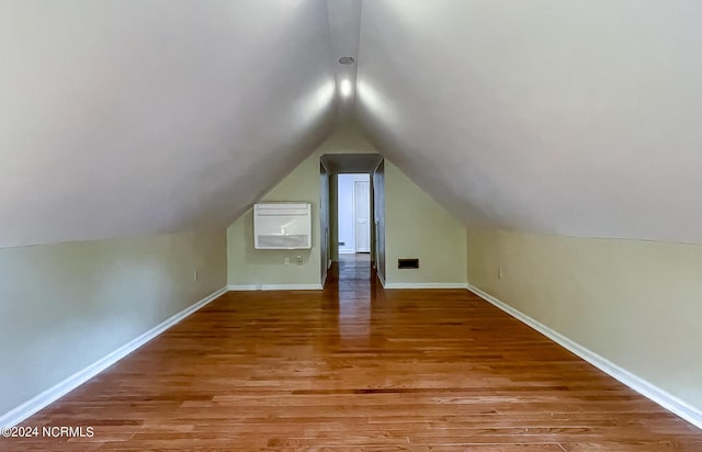 bonus room featuring vaulted ceiling, baseboards, and wood finished floors