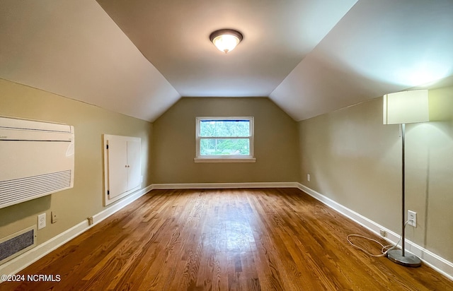 additional living space featuring dark wood-type flooring, vaulted ceiling, and baseboards