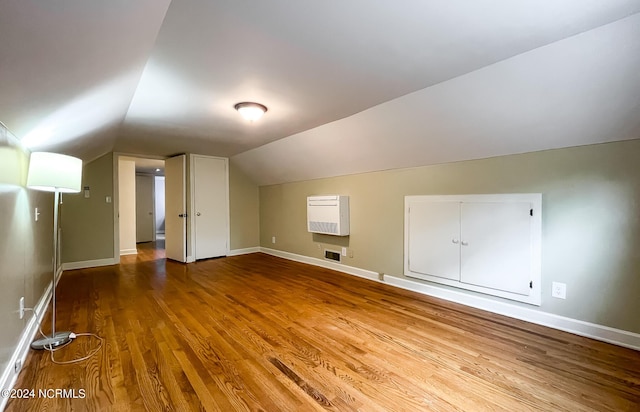 bonus room featuring lofted ceiling, baseboards, visible vents, and wood finished floors