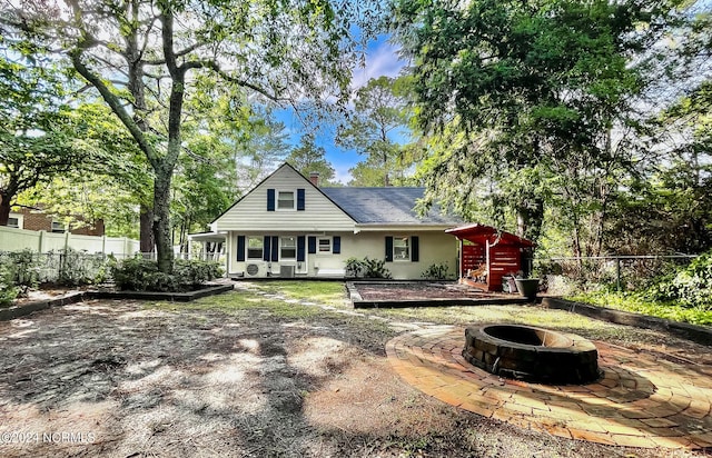 rear view of house with a fire pit and a fenced backyard