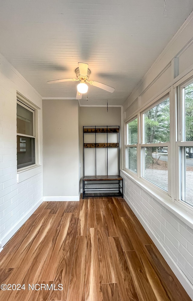 unfurnished sunroom featuring a ceiling fan