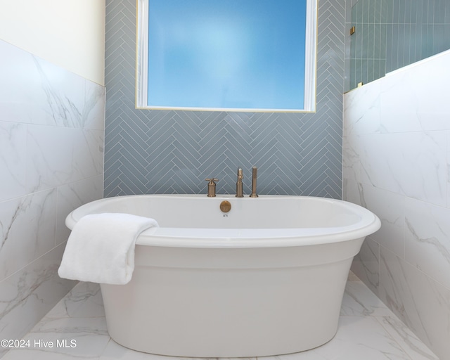 bathroom featuring a healthy amount of sunlight and tile walls