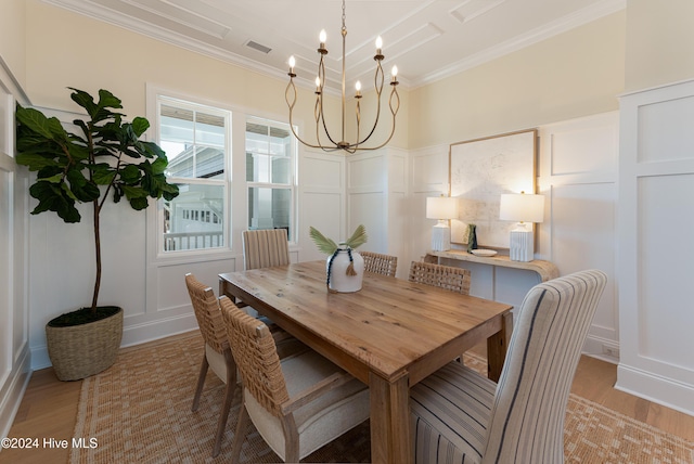 dining area featuring a chandelier, light wood-type flooring, and ornamental molding