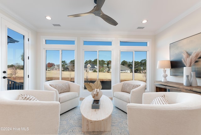 living room featuring a wealth of natural light, ornamental molding, and ceiling fan