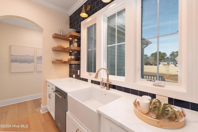 kitchen with white cabinets, light hardwood / wood-style floors, light stone countertops, and tasteful backsplash