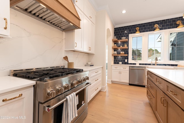 kitchen featuring stainless steel appliances, tasteful backsplash, light hardwood / wood-style floors, white cabinets, and custom exhaust hood