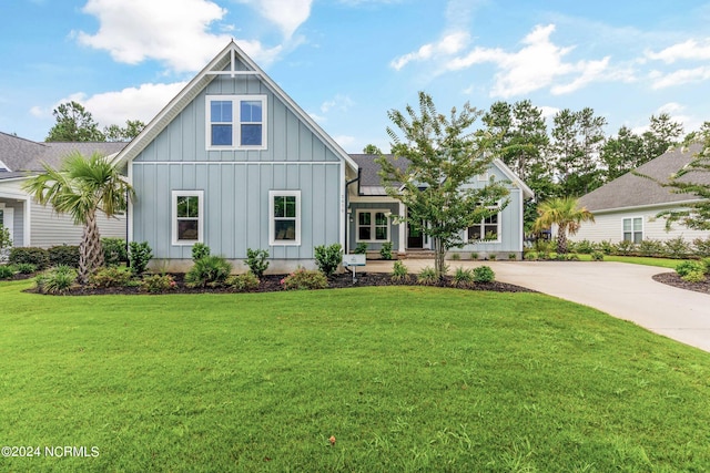 view of front of house featuring board and batten siding, concrete driveway, and a front yard