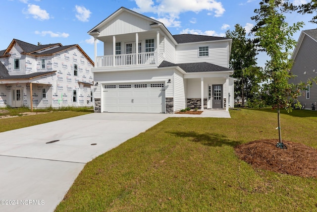 view of front of house with covered porch, a front yard, and a garage