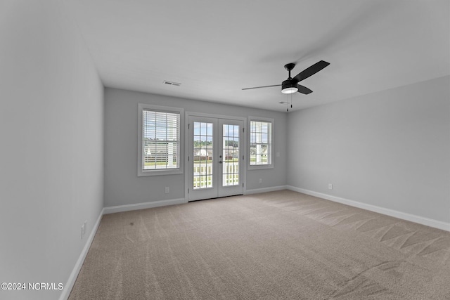 spare room featuring french doors, light colored carpet, and ceiling fan