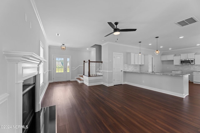 unfurnished living room with ceiling fan, dark hardwood / wood-style floors, and crown molding