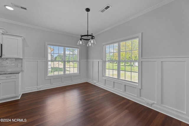 unfurnished dining area with a notable chandelier, dark hardwood / wood-style flooring, and crown molding