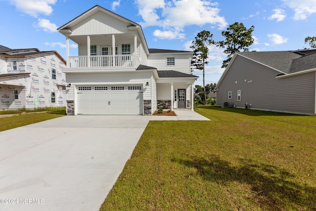 view of front of house with a porch, a front yard, and a garage