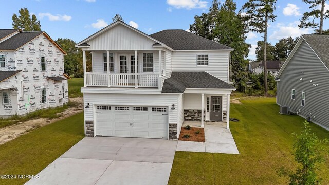 view of front of home featuring a front yard, a garage, and central AC unit