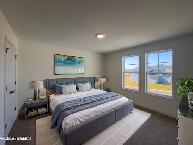 carpeted bedroom featuring baseboards and visible vents