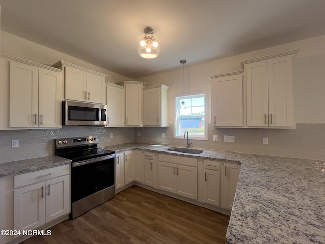 kitchen with decorative backsplash, white cabinetry, stainless steel appliances, and a sink