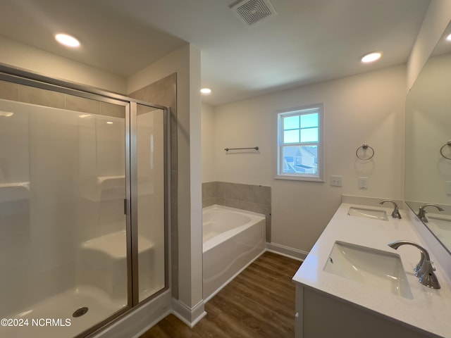 full bathroom featuring wood finished floors, visible vents, a sink, and a shower stall