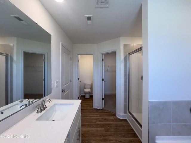 bathroom featuring wood finished floors, visible vents, and a shower stall