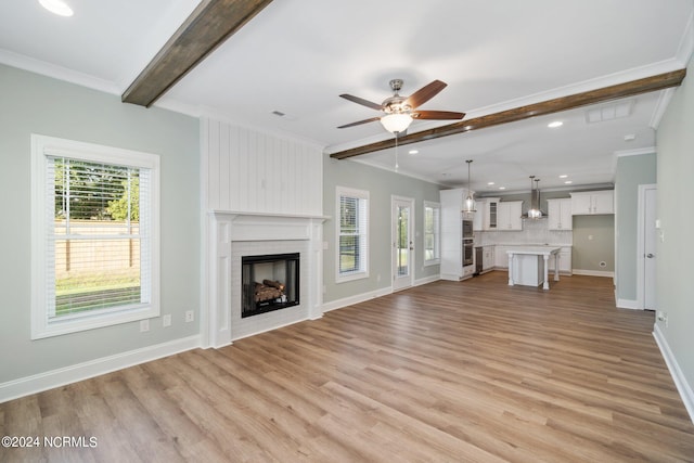 unfurnished living room featuring a fireplace, ceiling fan, ornamental molding, and light hardwood / wood-style floors