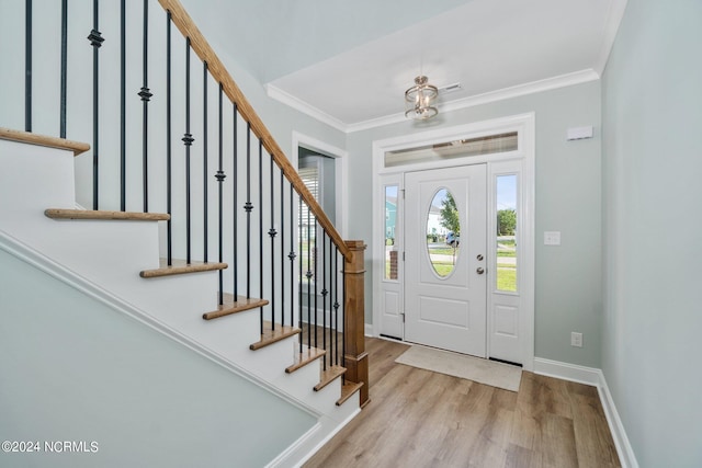 entryway with light wood-type flooring and ornamental molding