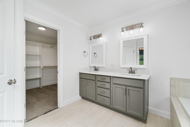 bathroom with crown molding, vanity, and tiled bath